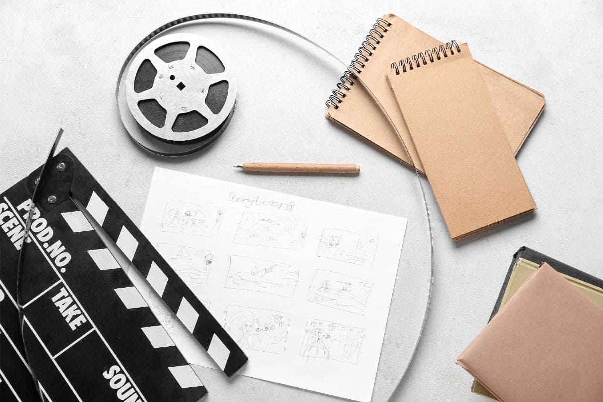 A film reel, notebook, pen, and other items neatly arranged on a table for a creative project.